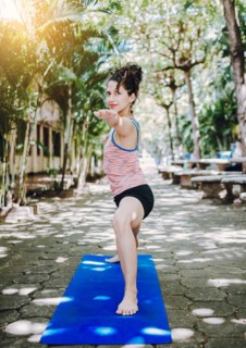 Young woman doing yoga virabhadrasana II outdoors. Girl practicing yoga Warrior II pose outdoors. Latin woman doing yoga warrior pose outdoors