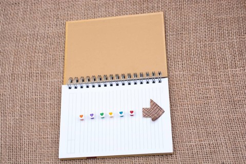 Love cubes and paper arrow on a notebook on canvas
