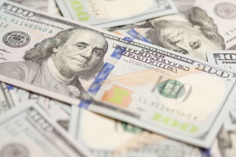One hundred dollar bills laying on flat surface
