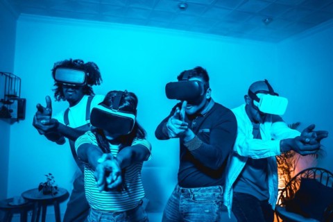 Group of young people with vr glasses in a virtual reality game in a blue light
