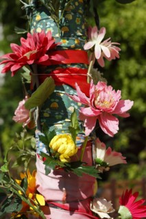 Pole of a streetlamp decorated with colourful artificial flowers