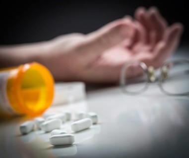 Man passed out on floor behind scattered drugs and medicine bottle