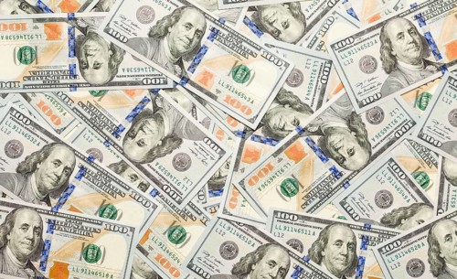 One hundred dollar bills laying on flat surface