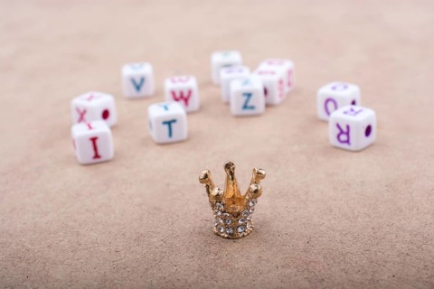 Golden color crown model in front of the letter cubes