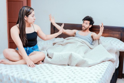 Upset woman with husband in bedroom bed