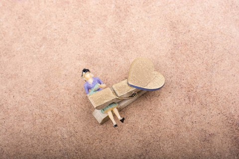 Woman figurine trapped in a clothespin on ground