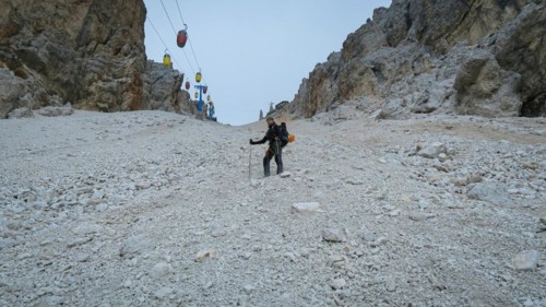 Tourist from the inventory trail in the gully with the gondola lift to Forcella Staunies