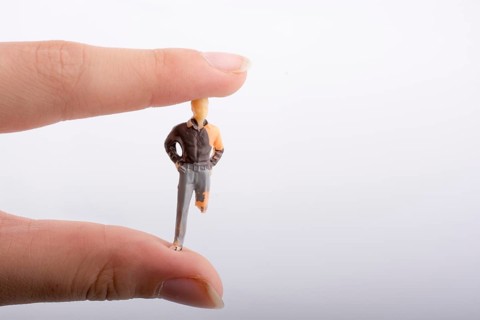 Little man figure with a crippled leg in hand on a white background