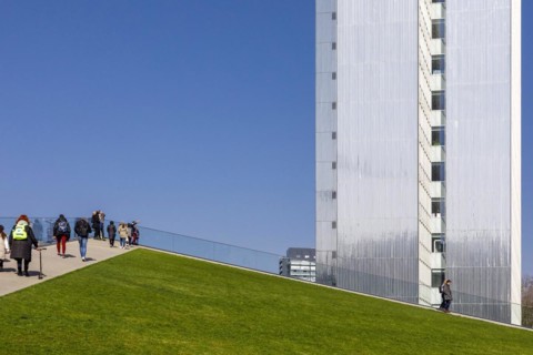 Three-slice house behind the walkable roof of the triangular pavilion