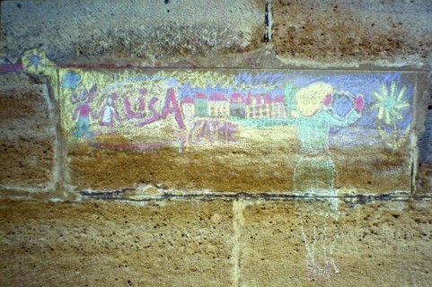 Faded chalk drawing on a house wall