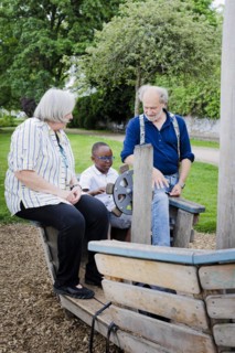 Temporary grandparents. Elderly couple volunteer to look after a boy from Africa for a few hours a week.