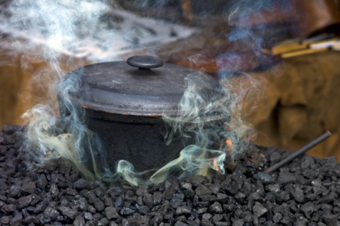 Cast iron pot on the charcoal for tempering the forged material