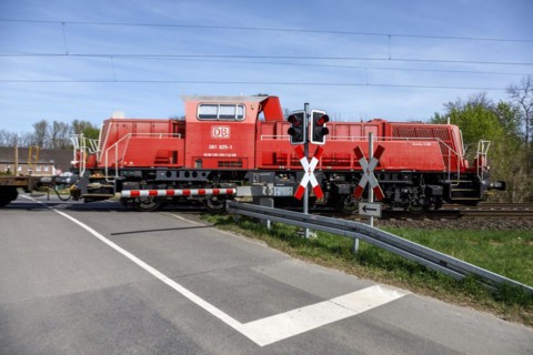 Passing goods train with locomotive Gravitation 10 BB at level crossing