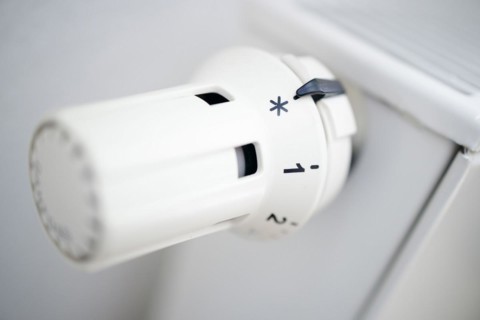 Symbol photo on the subject of increased heating costs. The thermostat of a heating system is set to the symbol snowflake