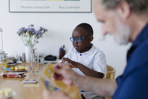Temporary grandparents. Elderly couple volunteer to look after a boy from Africa for a few hours a week.
