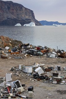 Rubbish at garbage dump and icebergs at the fishing village Uummannaq