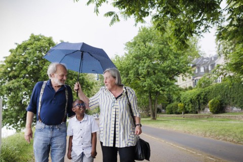Temporary grandparents. Elderly couple volunteer to look after a boy from Africa for a few hours a week.