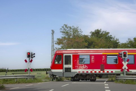 Passenger train passing a level crossing with barriers