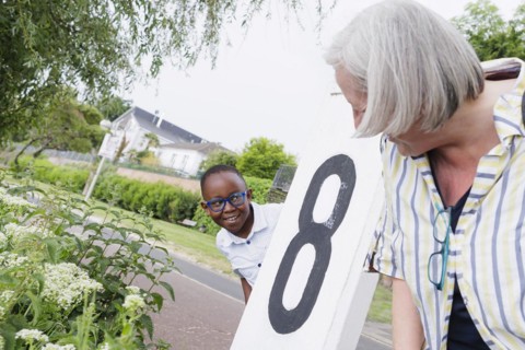 Temporary grandparents. Elderly couple volunteer to look after a boy from Africa for a few hours a week.