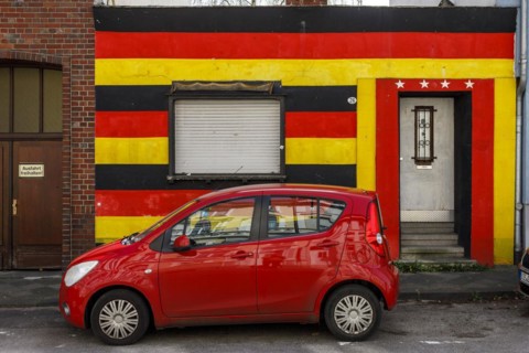 Front of a residential building in the German national colours black-red-gold and 4 stars above the entrance door