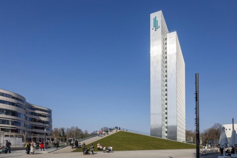 Three-slice house behind the walkable roof of the triangular pavilion