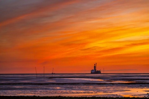 View from the Trischendamm to Germanys only drilling platform Mittelplate after sunset at low tide