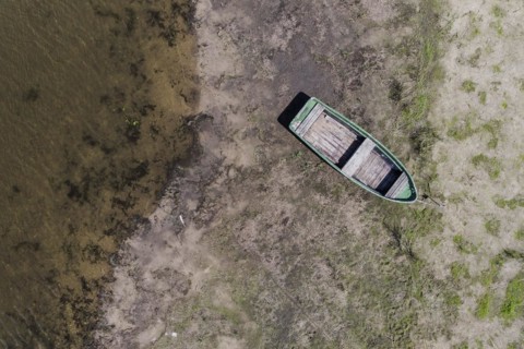 A boat lies on a dry bank at low water level