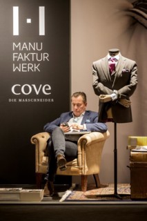 Businessman in exhibition stand of Manufakturwerk Cove die Massschneider