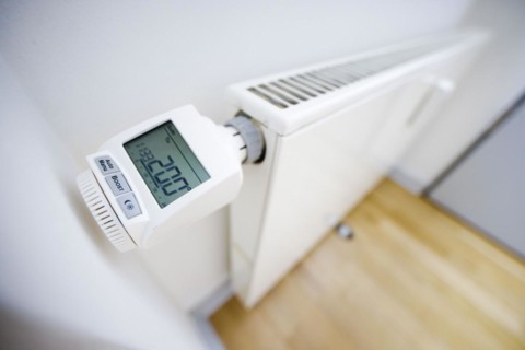 Symbolic photo on the subject of increased heating costs. Programmable radiator controller on a radiator. Berlin