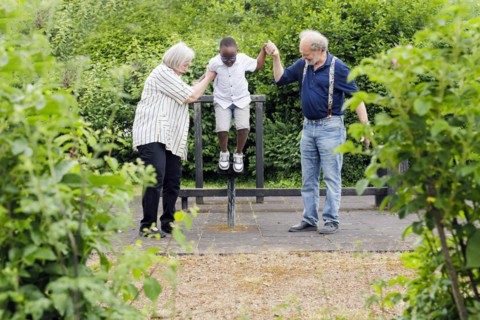 Grandparents on time. Grandparents with a boy on a playground.