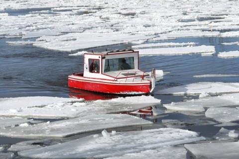 Small red boat between ice sheets