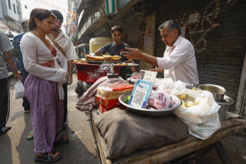 Street vendor with paytm logo for cashless payment at his stall in Paharganj