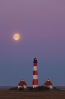 Lighthouse Westerheversand at sunset with full moon at Westerhever