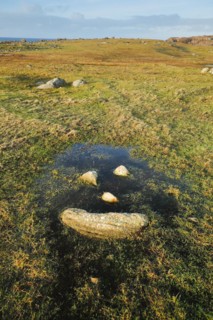 Natural smiley made of stones in the middle of a puddle of water in a meadow in the Highlands of Scotland