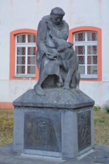 Monument with relief and sculpture of St. Francis with wolf figure at the former Jesuit monastery
