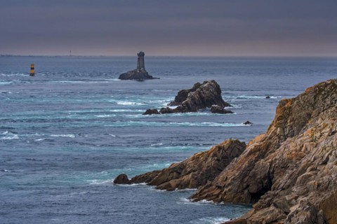 The lighthouse La Vieille in the strait Raz de Sein at dusk at the Pointe du Raz