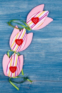 Three fabric tulips with three hearts on a blue background