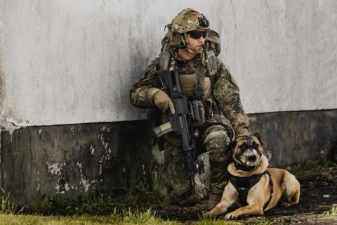 A soldier of the German Armed Forces with a mission dog