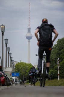 Cyclists ride along Karl Marx Allee on a cycle path towards Mitte. The television tower can be seen in the background. Berlin