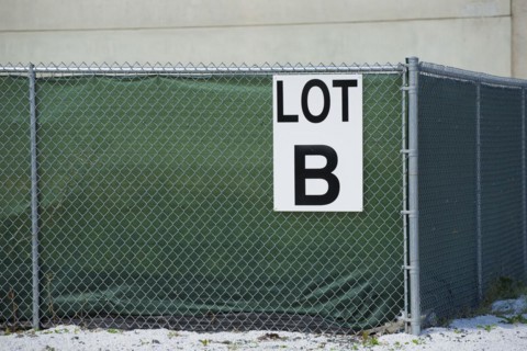 Sign on a chain-link fence reading
