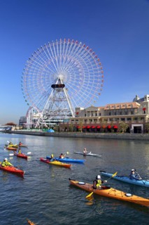 Group of kayaks on excursion and Ferris Wheel Cosmo Clock 21 of Yokohama Cosmo World in background Yokohama city Kanagawa Japan