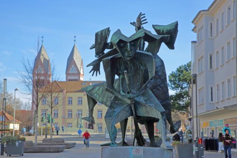 Fools' Fountain with sculptures Witch and Witch's Broom by Willi Dorn 1964 with Holy Trinity Church