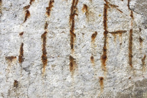 Rusty metal in concrete wall
