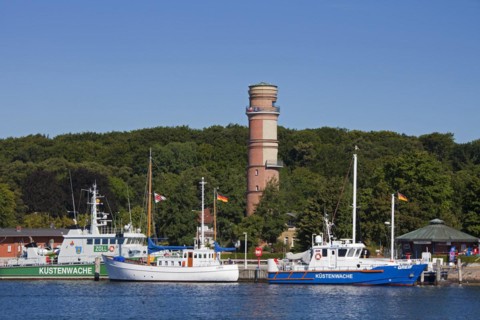 Coastguard patrol boats and the old lighthouse in the port of Travemuende at dusk