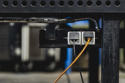 Two plugs stuck in sockets under a worktop
