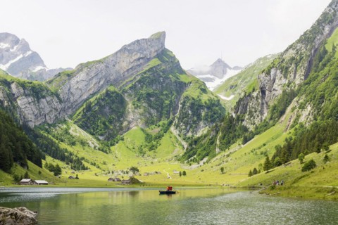 Two musicians blowing the alphorn in a boat