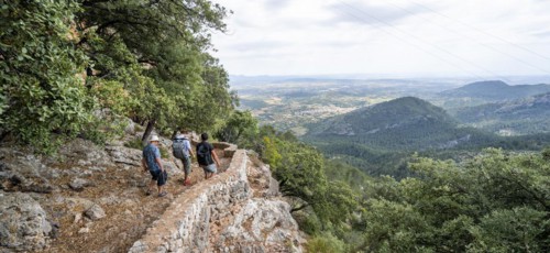 Hikers on the trail to the castle ruins of Castell Alaro