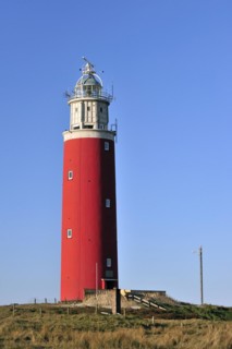 The red Cocksdorp lighthouse Eierland in the dunes on the island Texel
