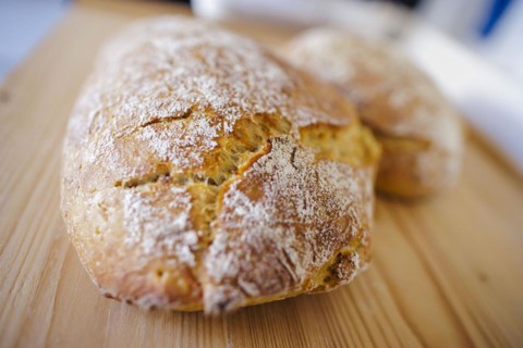 Symbolic photo on the subject of wheat bread. Freshly baked wheat bread lies on a board. Berlin