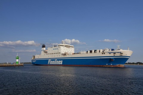 Ro-ro passenger ferry Finnpartner from Finnlines passing lighthouse Travemuende Nordmole